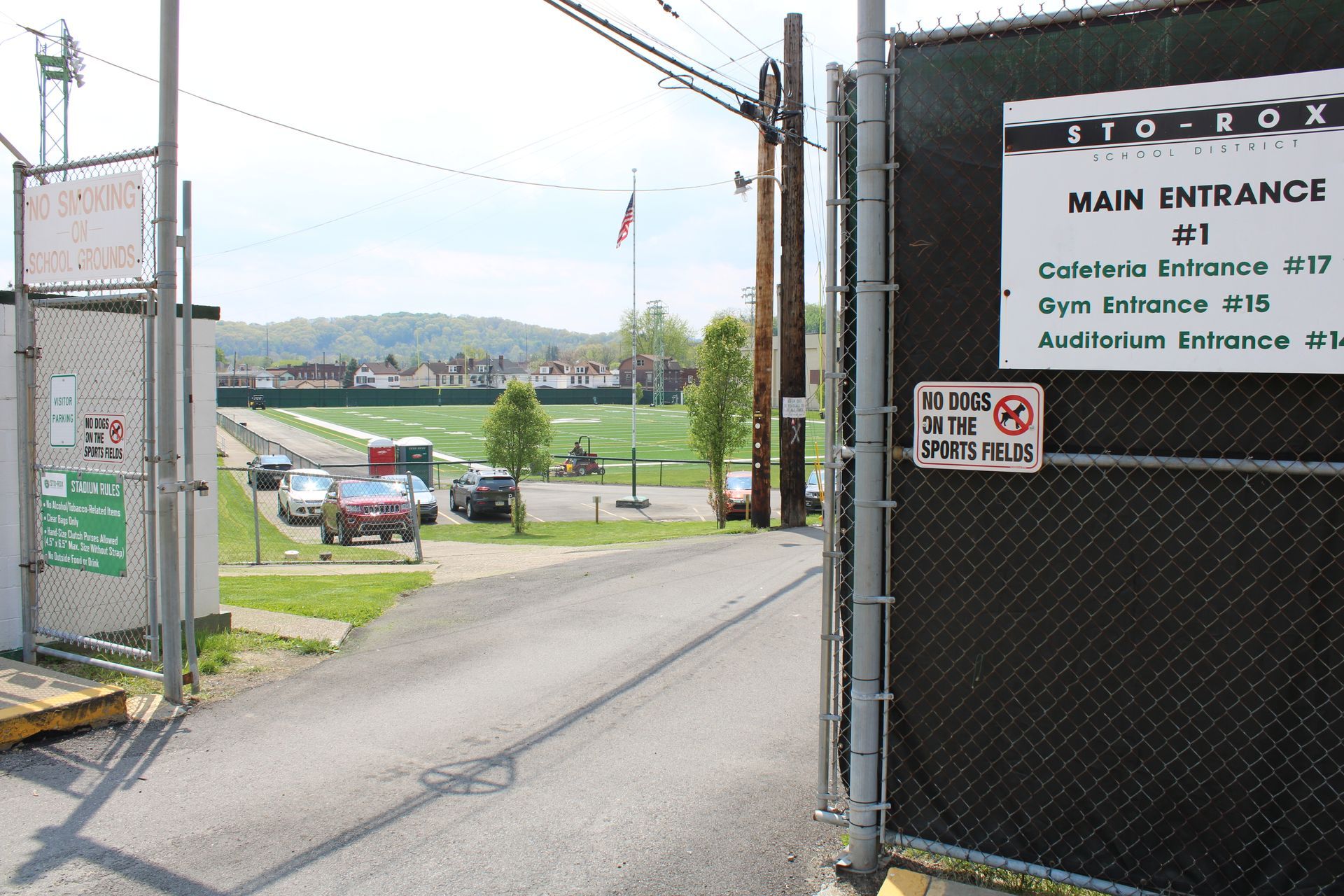 A fence with a sign that says main entrance on it