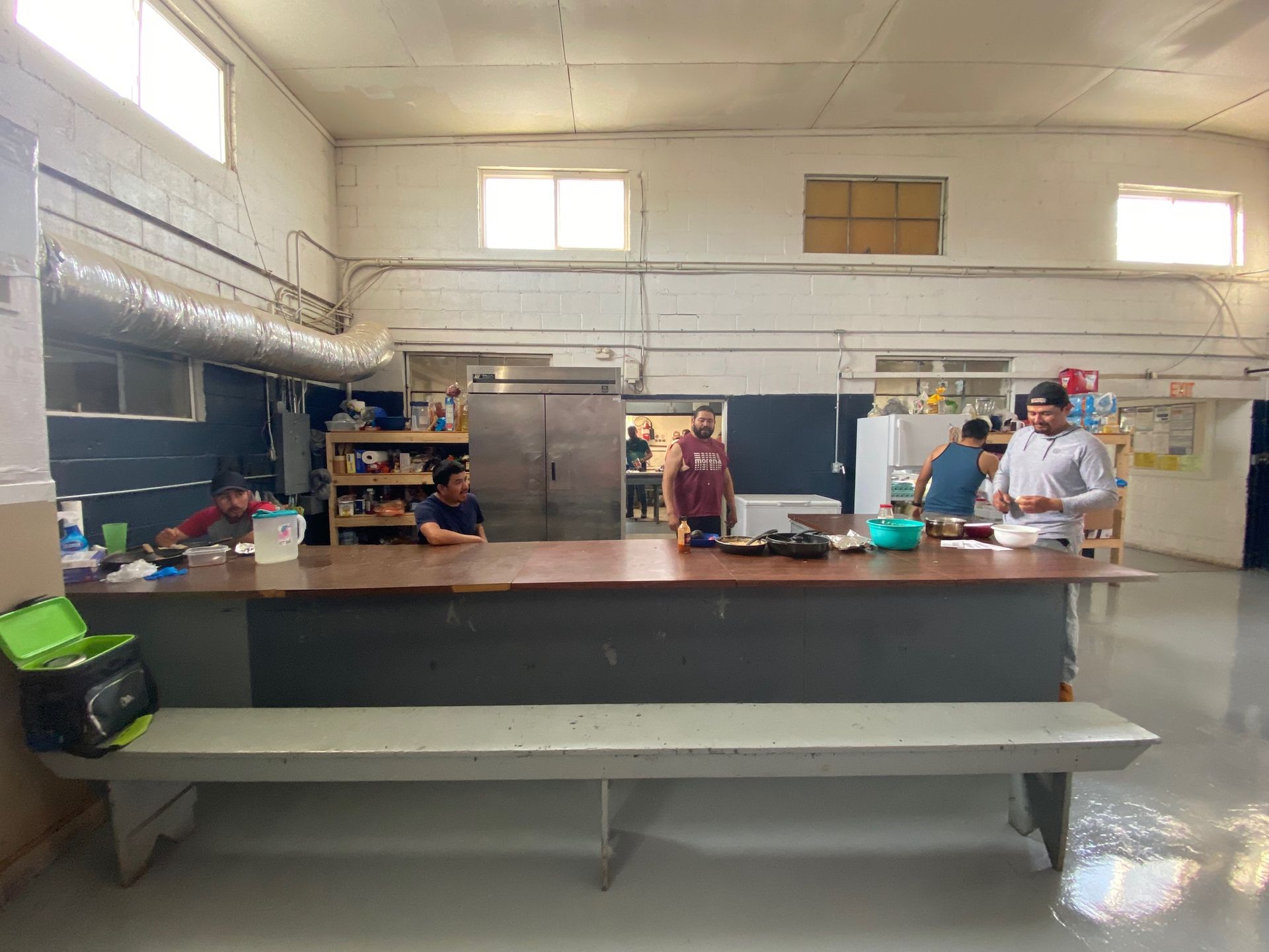 A group of people are standing around a long table in a room.