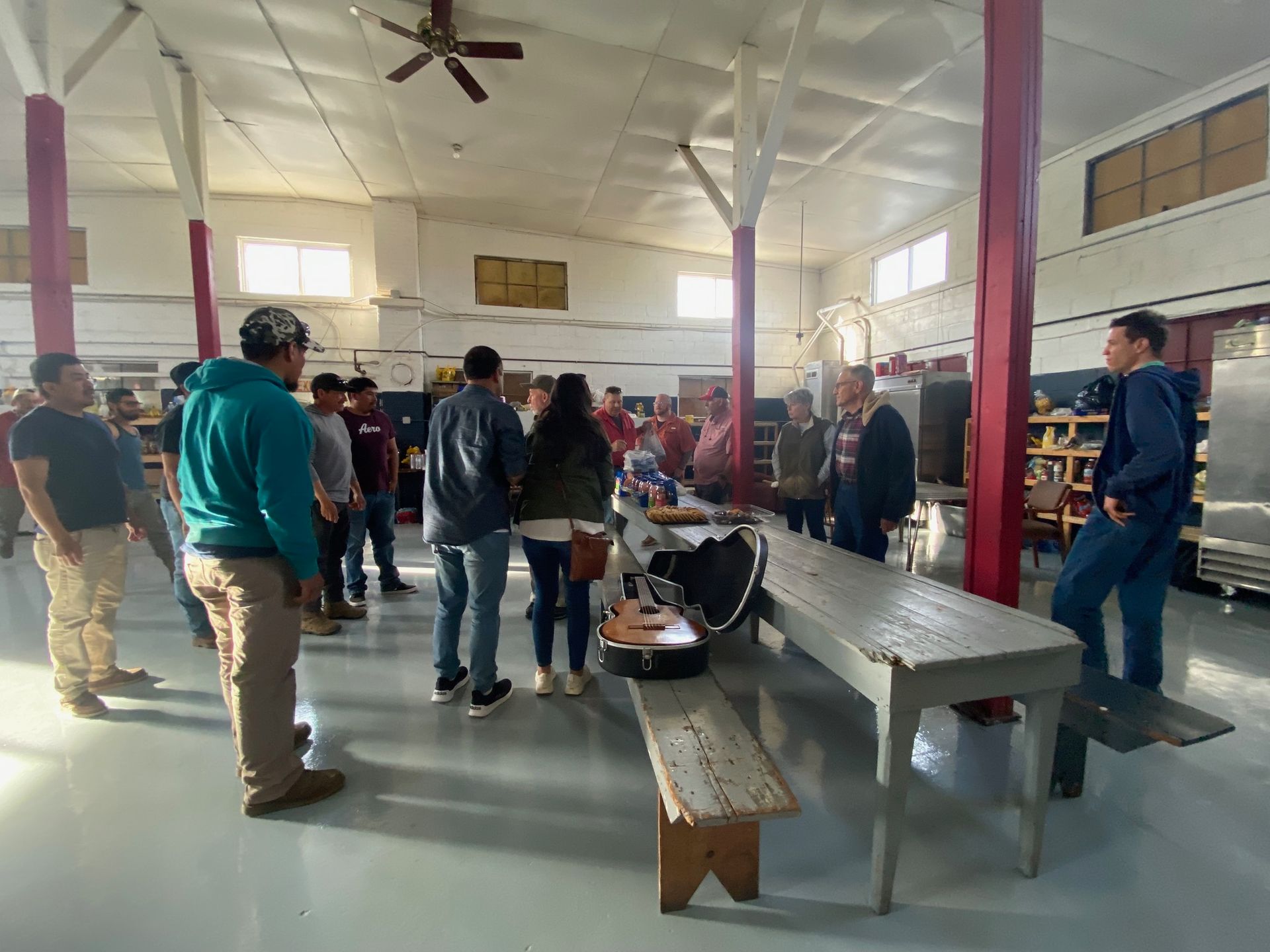 A group of people are standing around a table in a room.