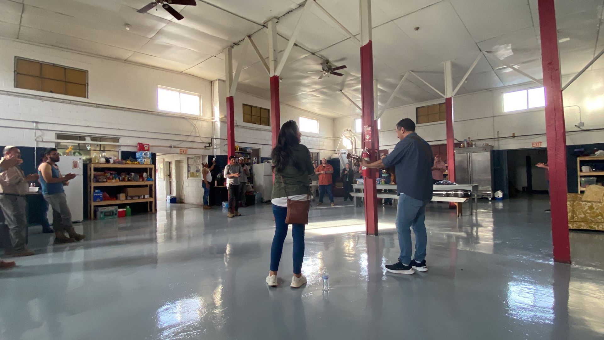 A group of people are standing in a large room.