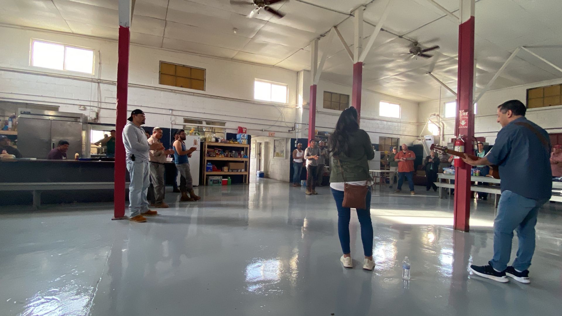 A group of people are standing in a large room.