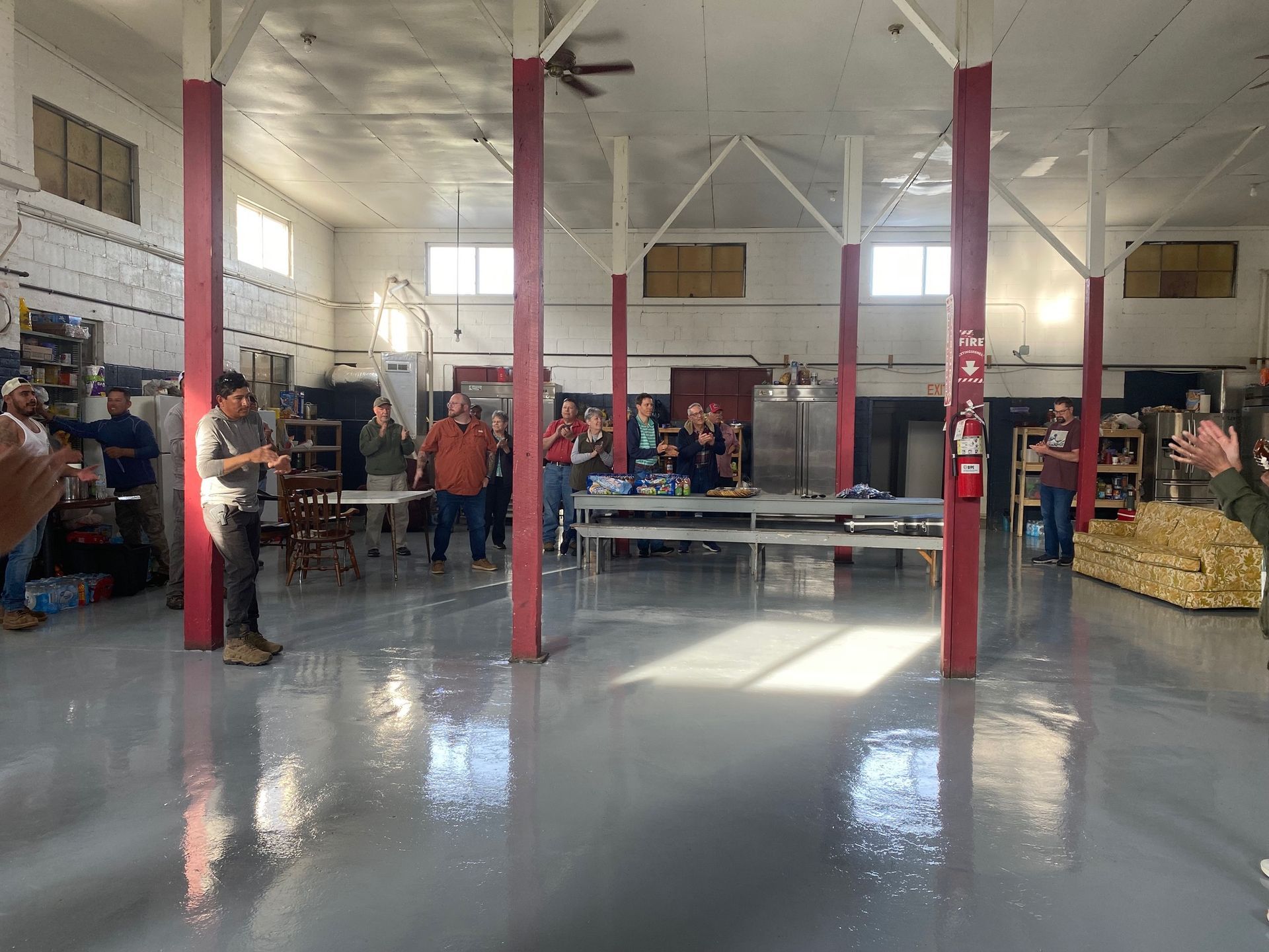 A group of people are standing in a large room.