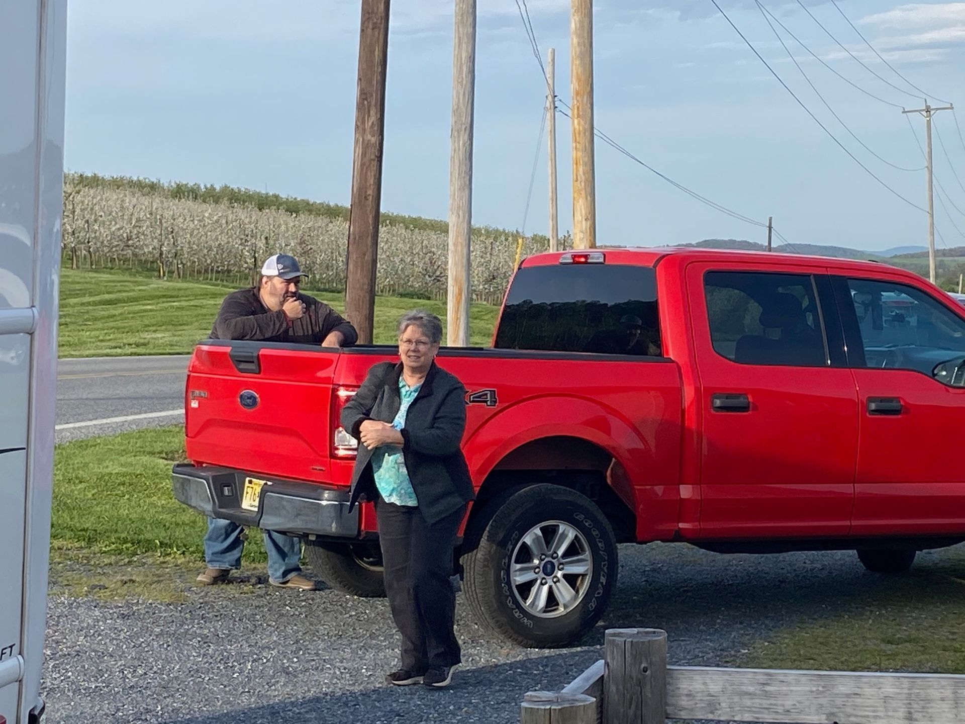 A man and a woman are standing next to a red truck.