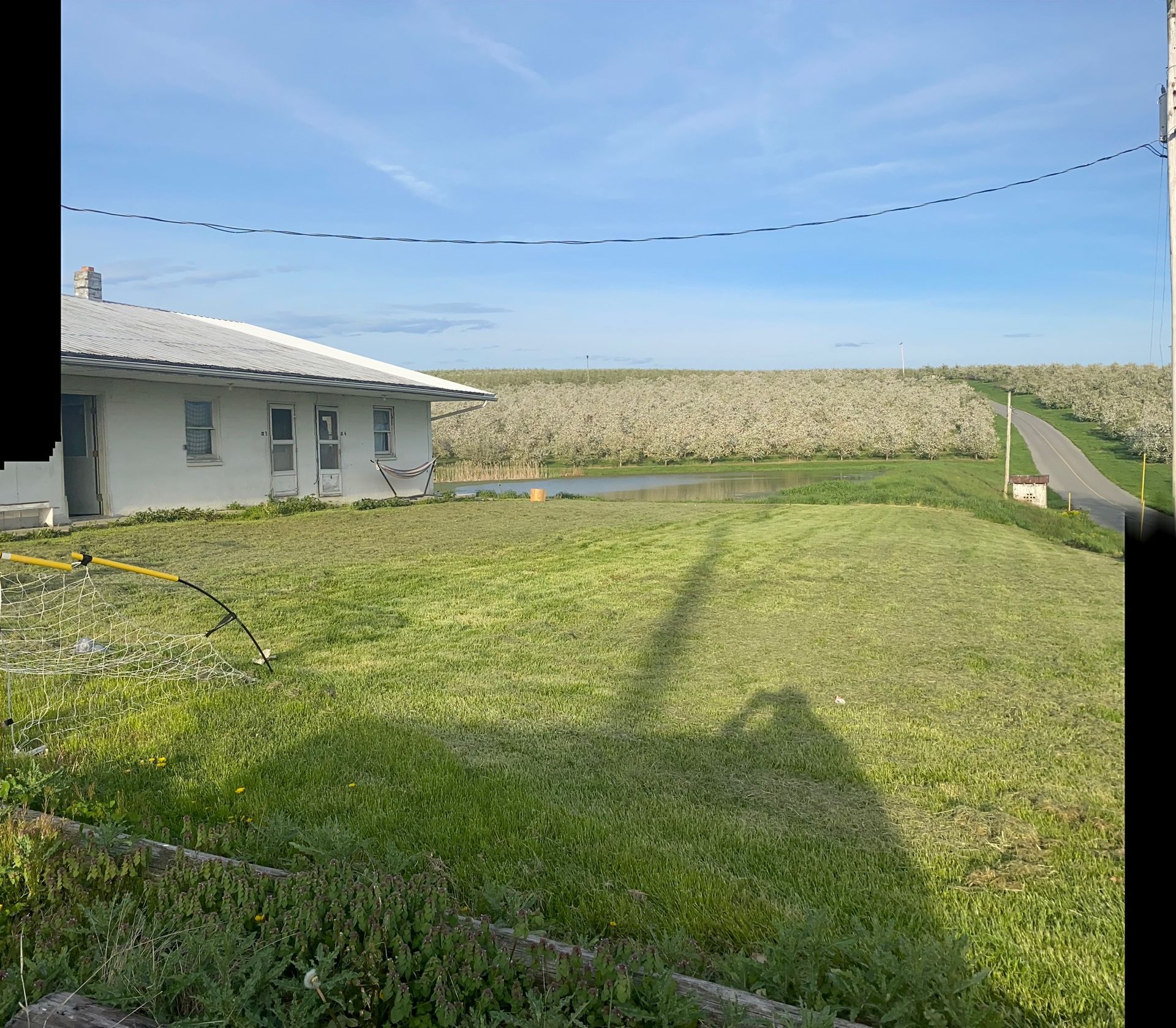 A white house is sitting in the middle of a grassy field.
