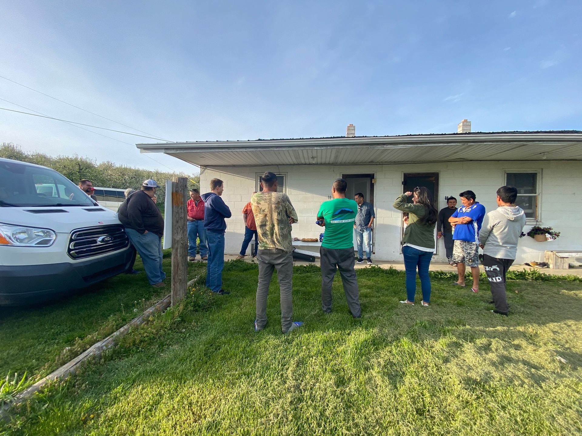 A group of people are standing in front of a house.