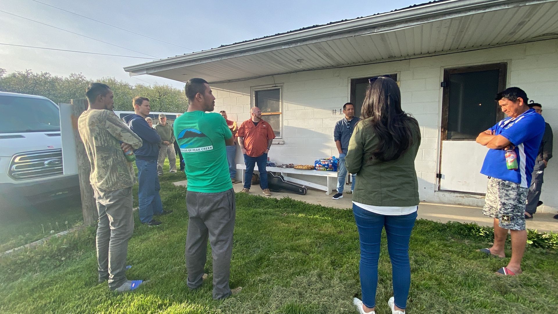 A group of people are standing in front of a house.