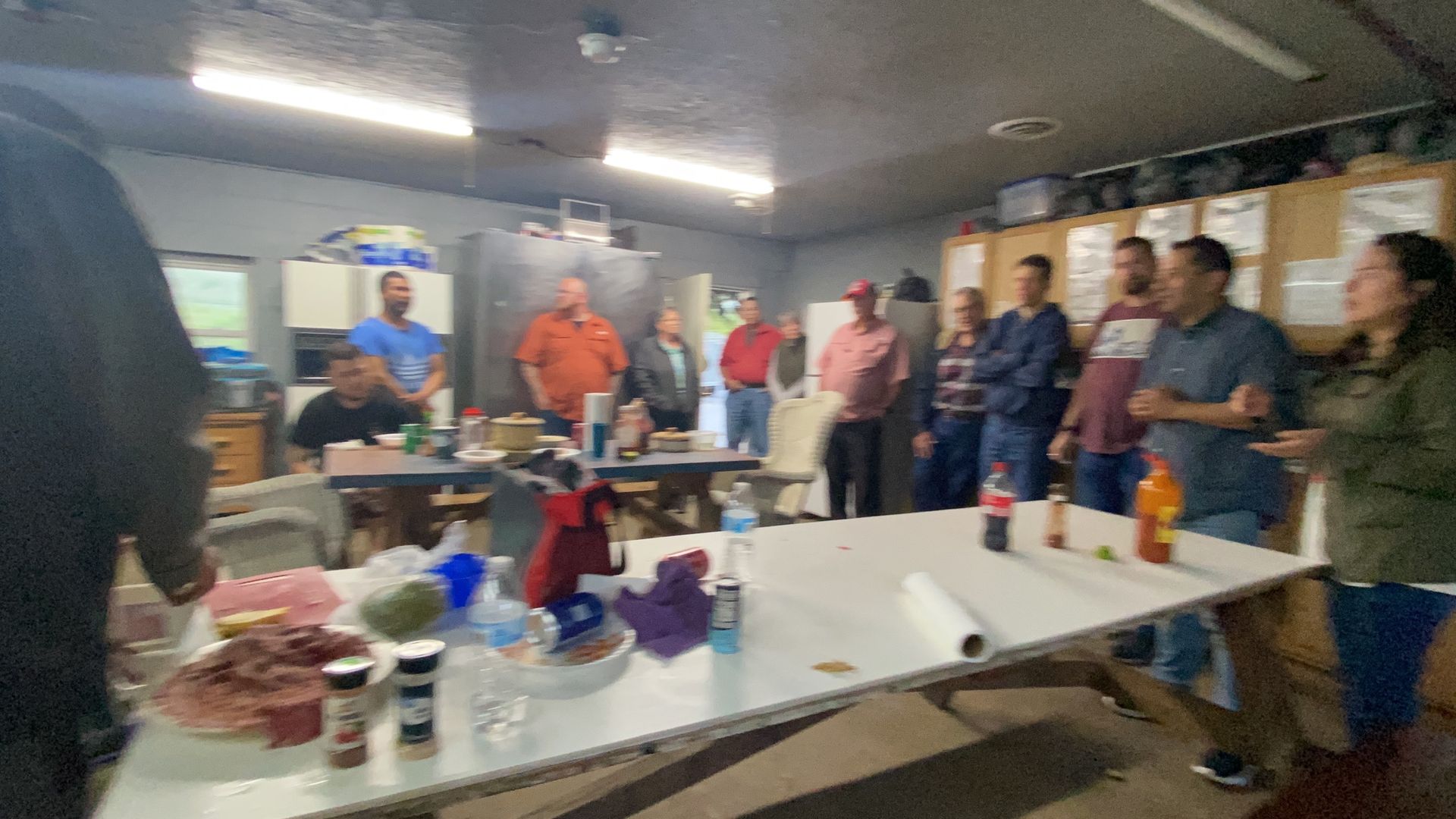 A group of people are standing around a table in a room.