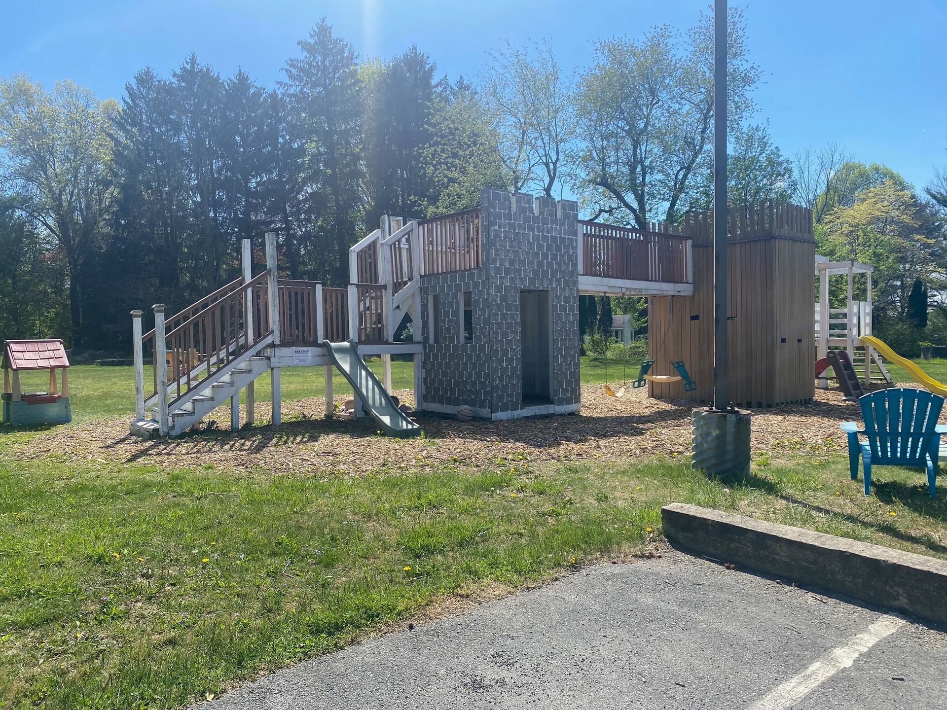 A playground with a castle and a slide in a park.