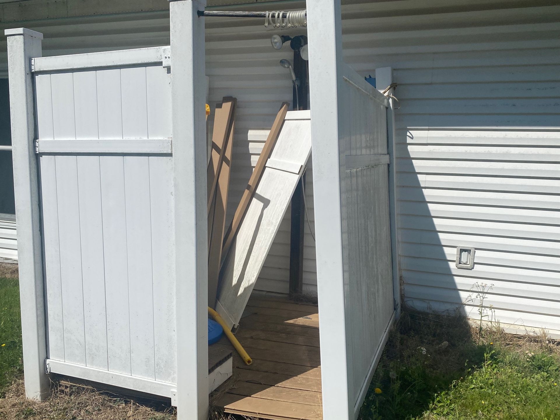 A white fence is in front of a white house