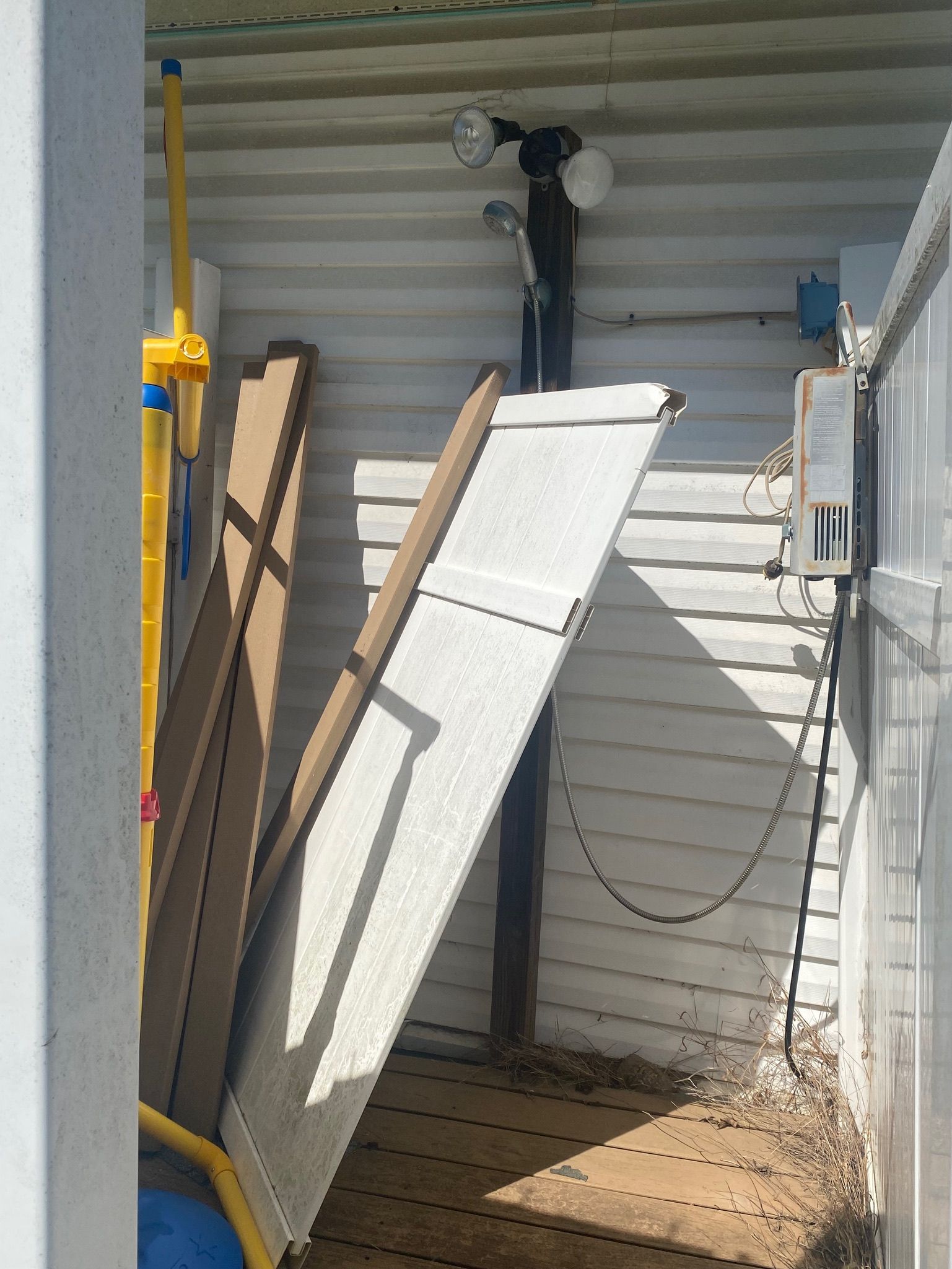 A shed with a white door and a yellow pole