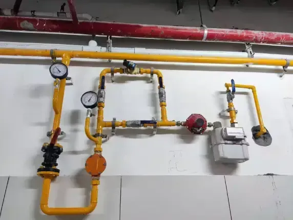 A bunch of yellow pipes are hanging on a wall.