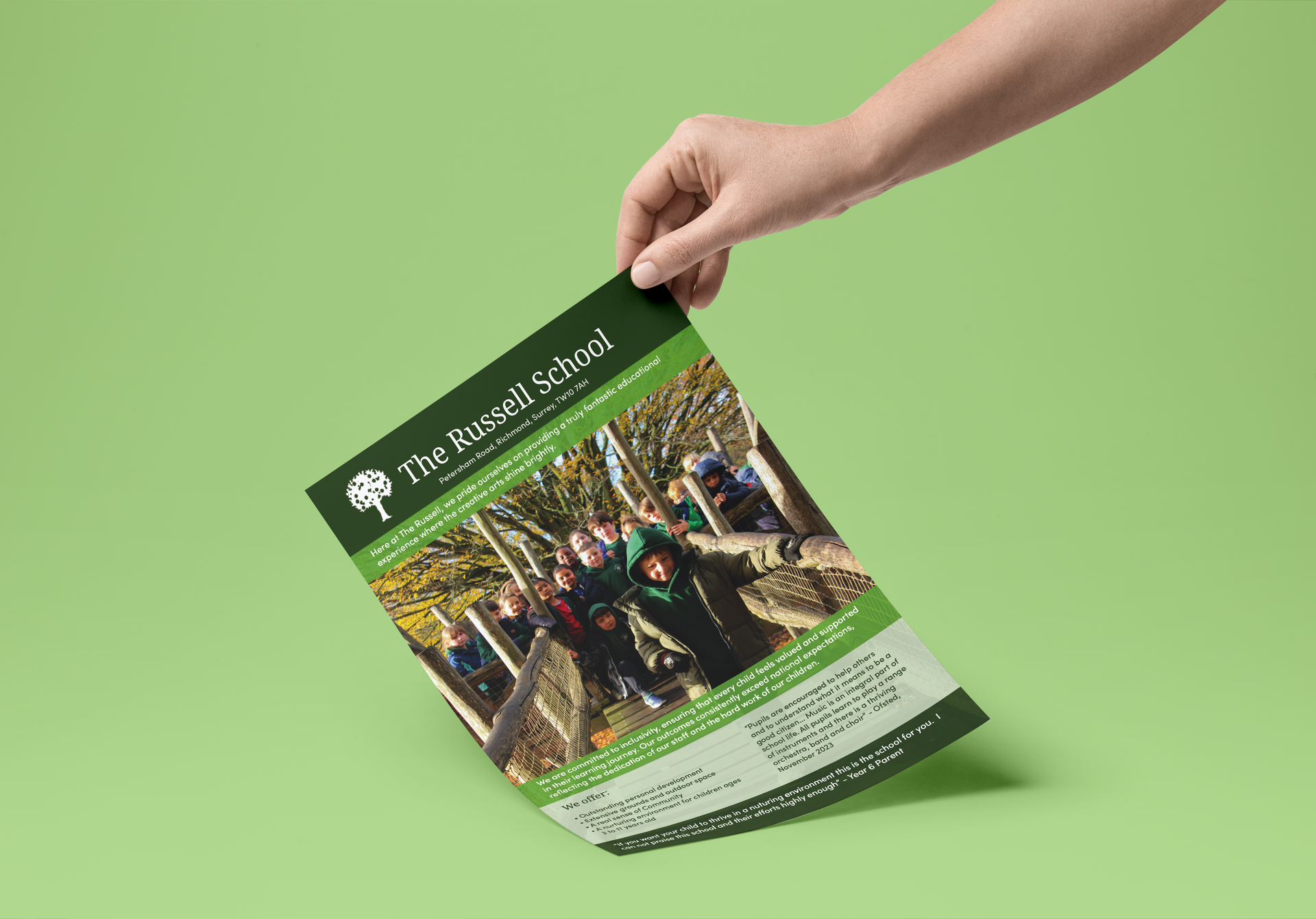 A person is holding a piece of paper with a picture of a group of people on it.