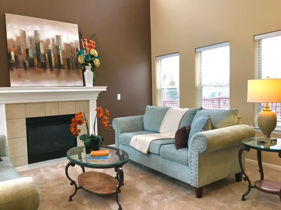 A living room with a blue couch and a fireplace