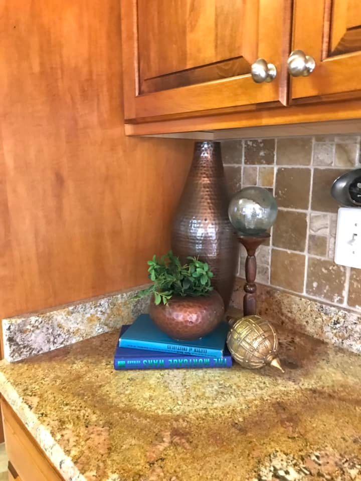 A kitchen counter with a vase and books on it.