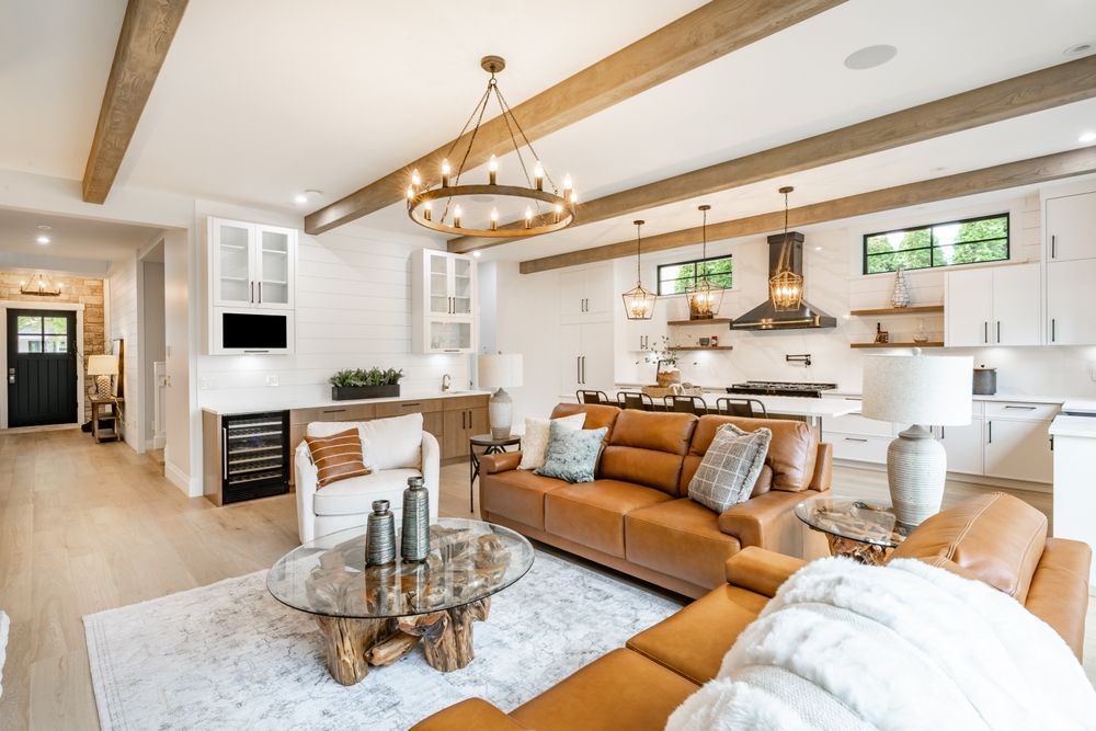A living room with a brown couch and a glass coffee table.
