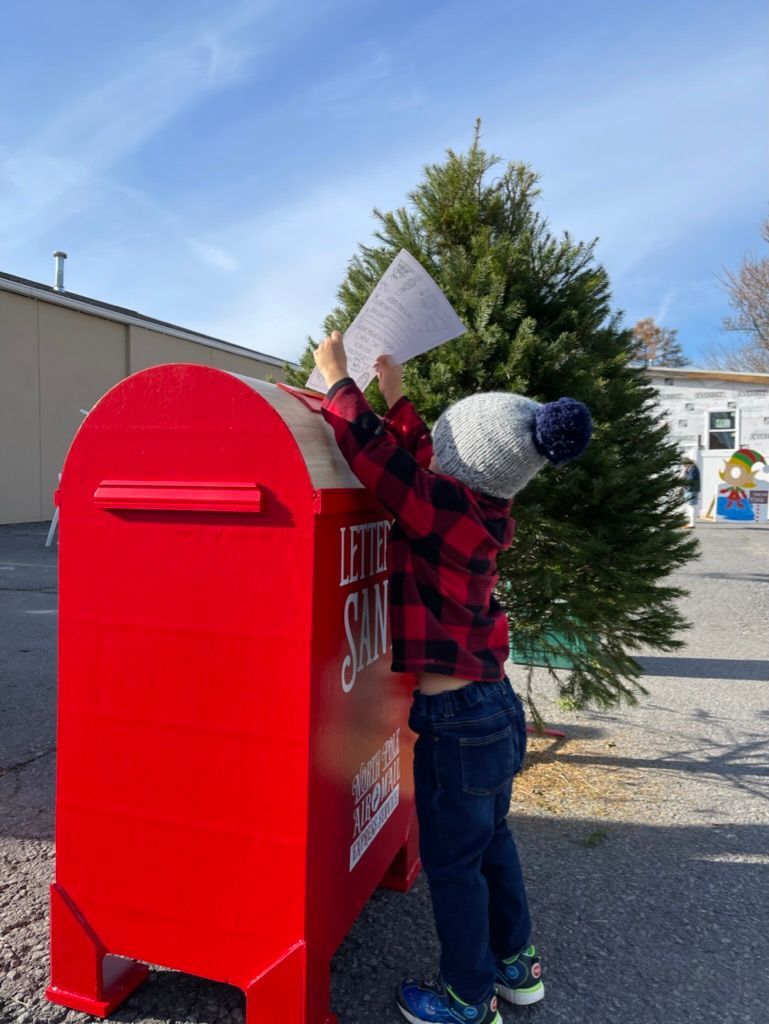 A little boy sending a letter to Santa.