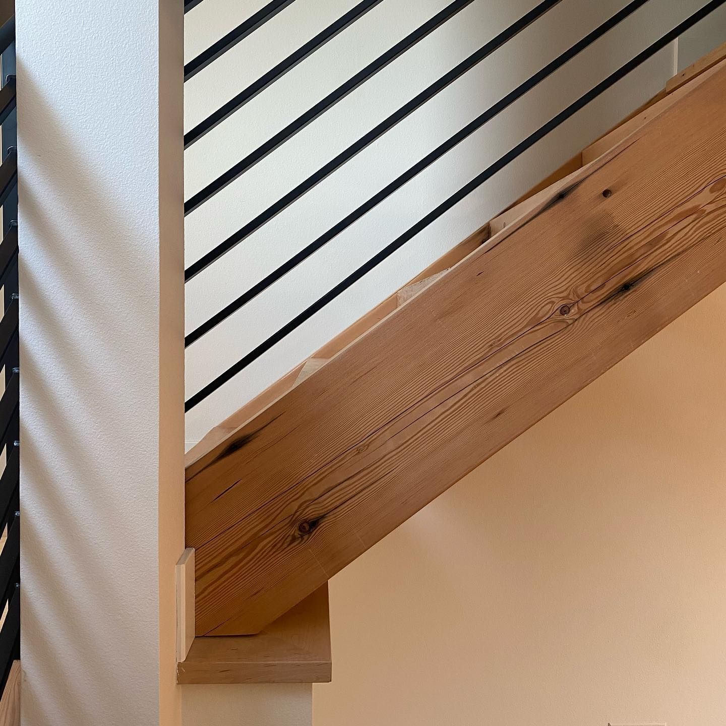 A close up of a wooden staircase with a metal railing