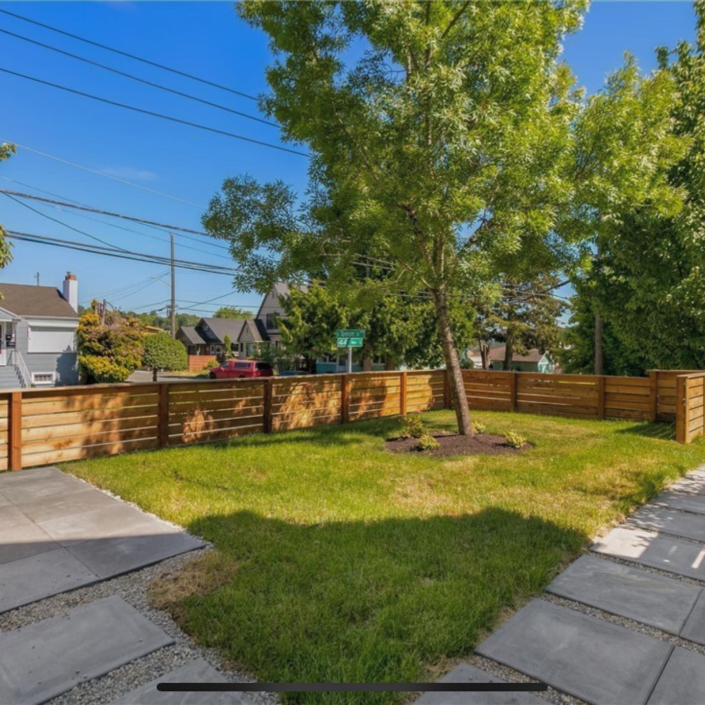 A backyard with a wooden fence and trees