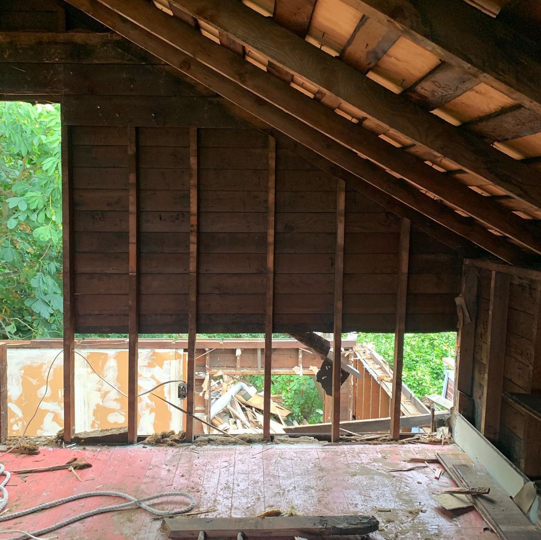 A room with a wooden wall and a window.
