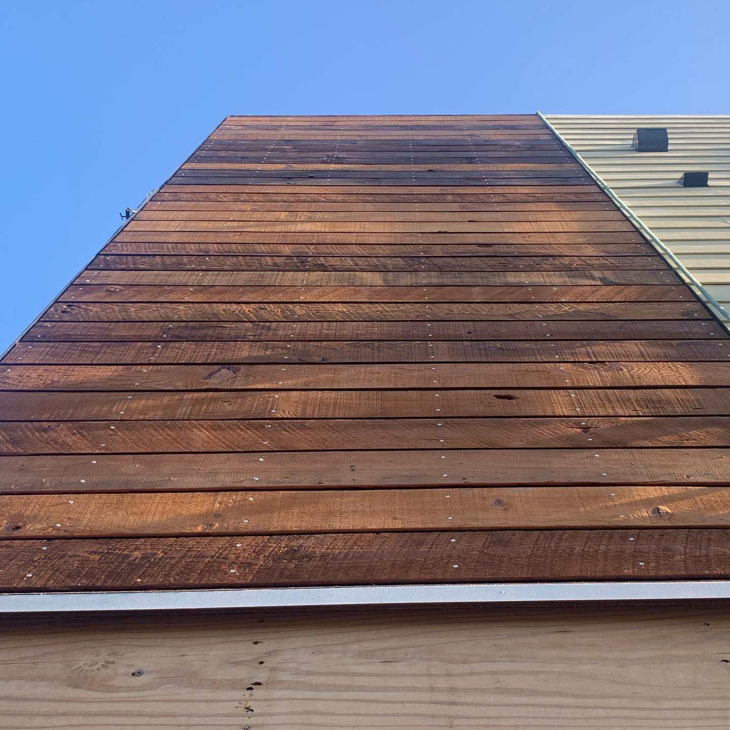 A wooden roof with a blue sky in the background