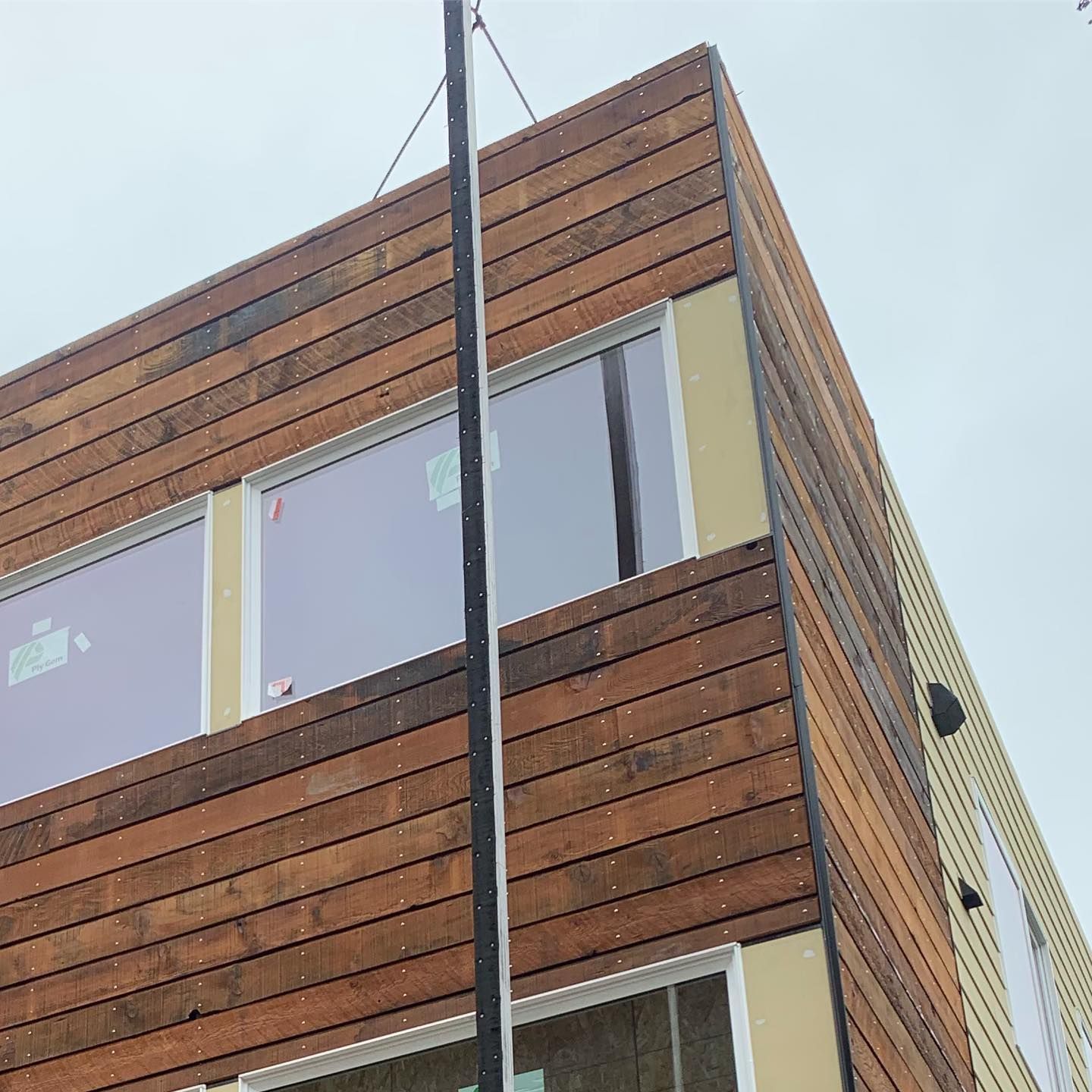 A building with wooden siding and windows is being built