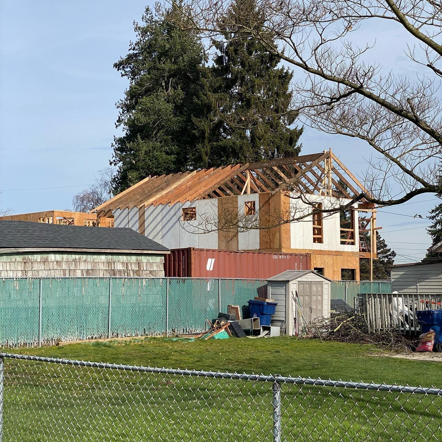 A house is being built with a shipping container in front of it