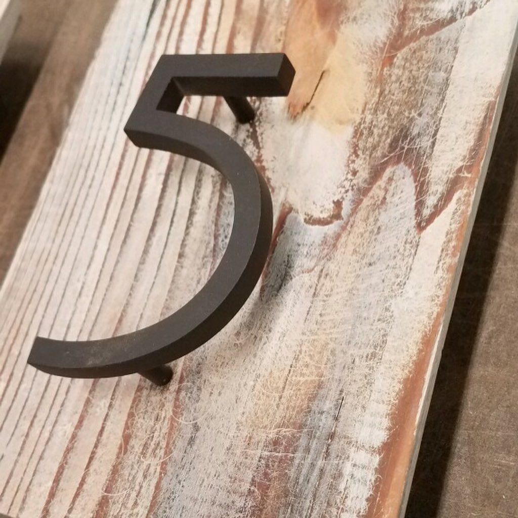 A wooden sign with the number 5 on it