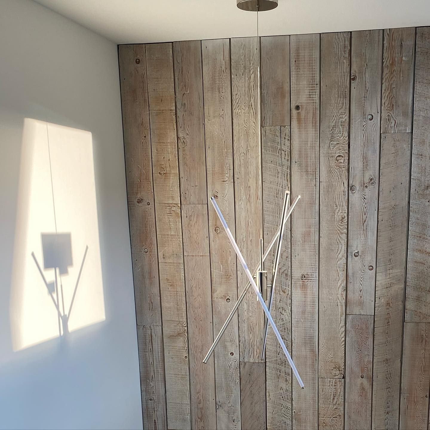 A room with a wooden wall and a light hanging from the ceiling.