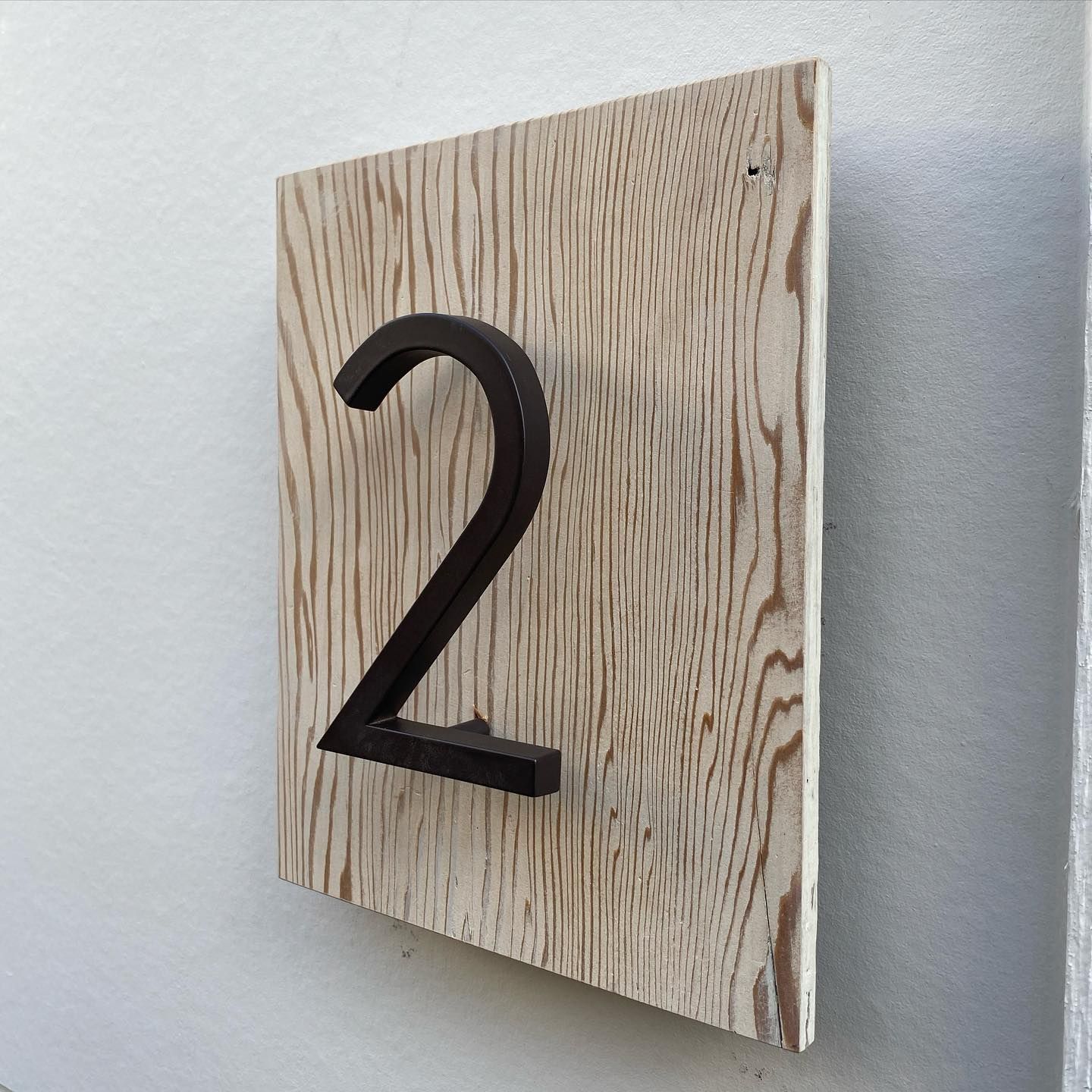 A wooden sign with the number 2 on it