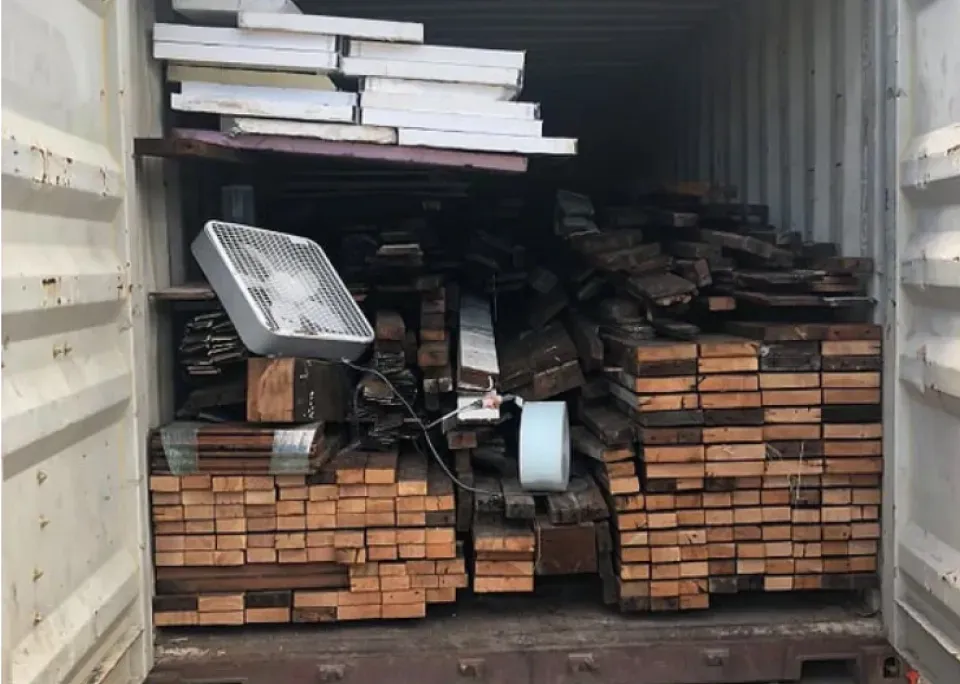 A container filled with lots of wood and a fan