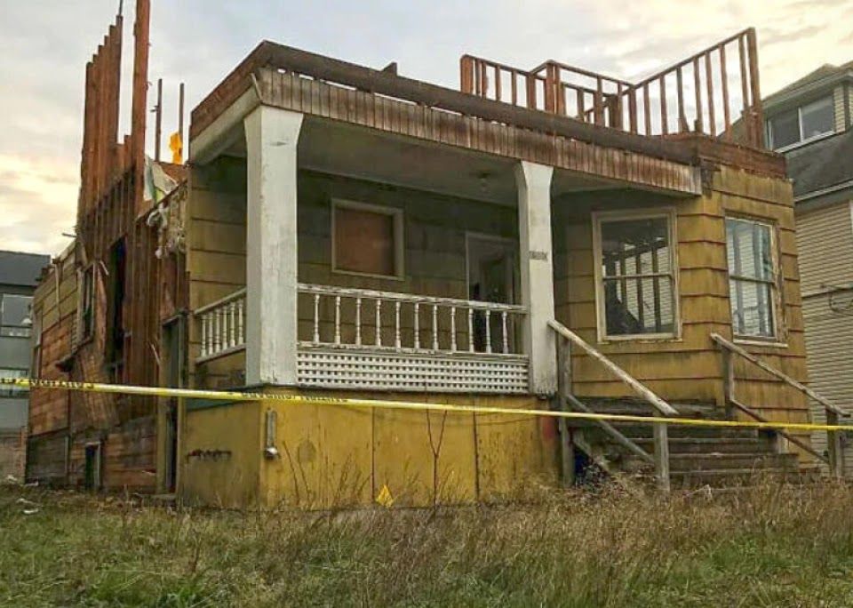 An old house with a porch is being demolished.