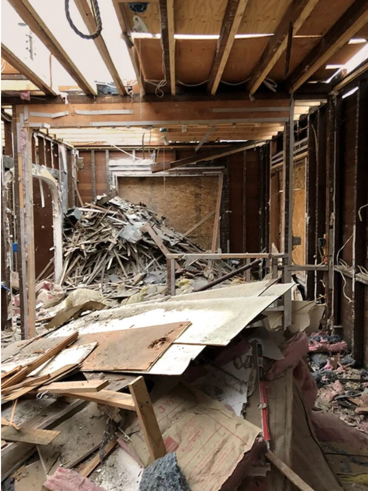A pile of wood is sitting in the middle of a building under construction.