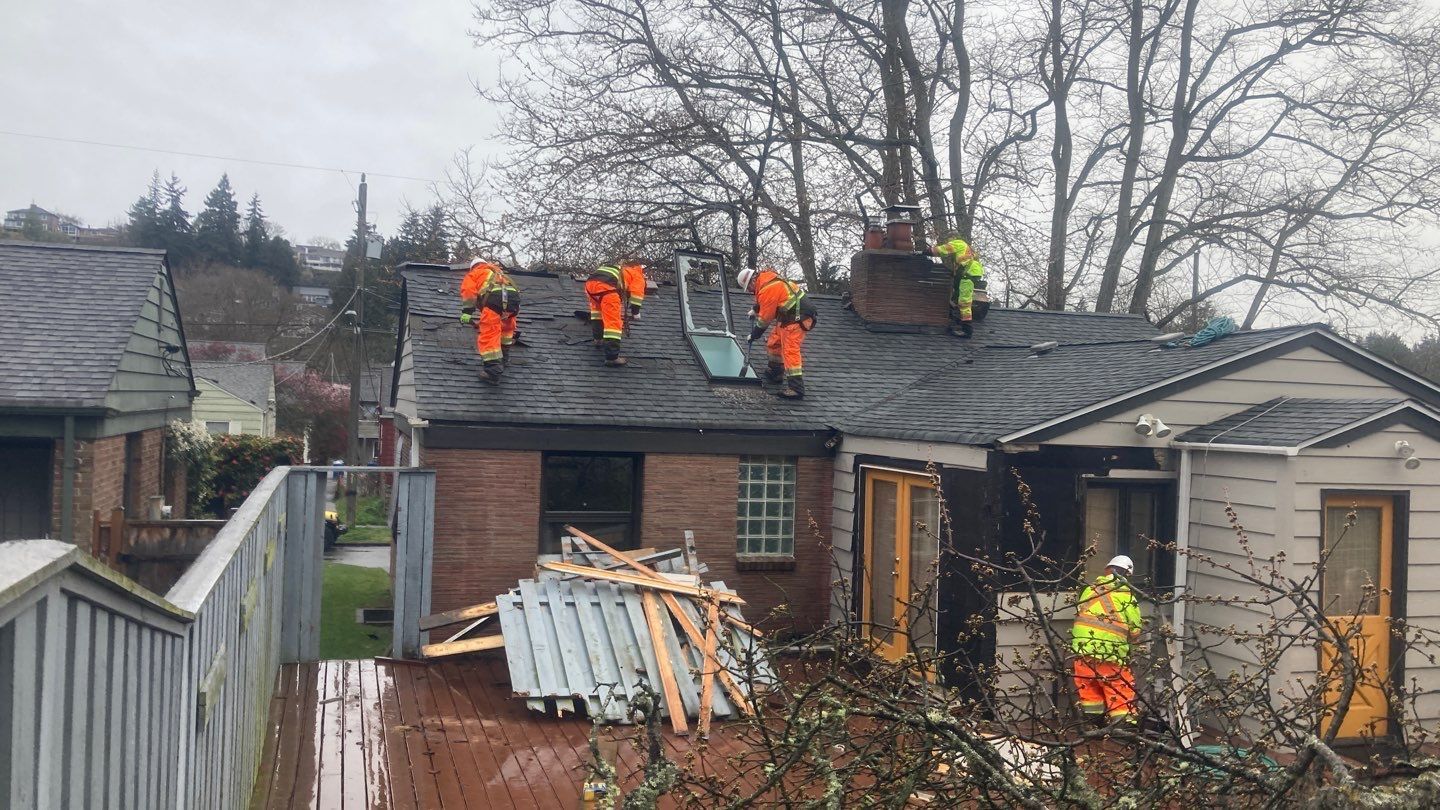 A group of men are working on the roof of a house.