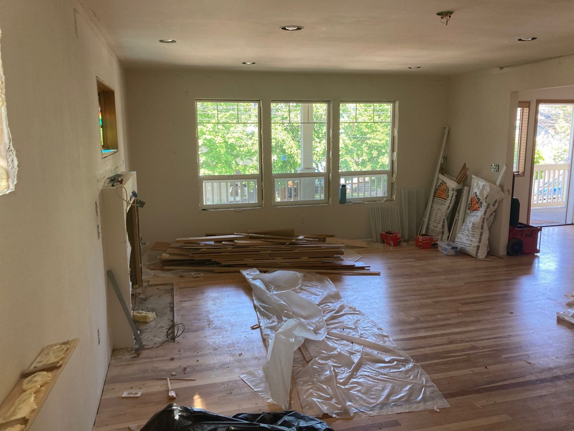 A living room with hardwood floors and a lot of windows.