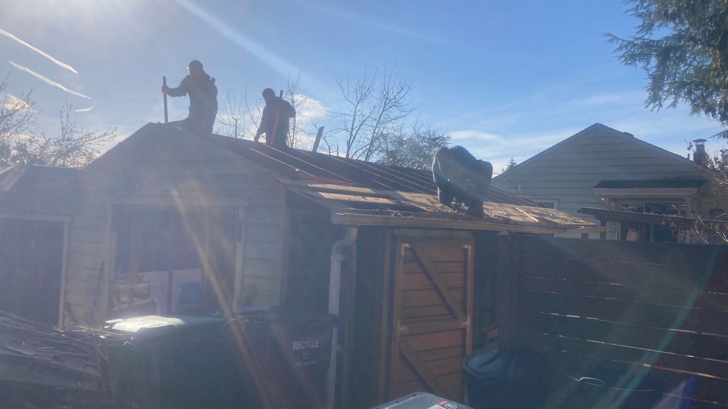 Two men are working on the roof of a house.