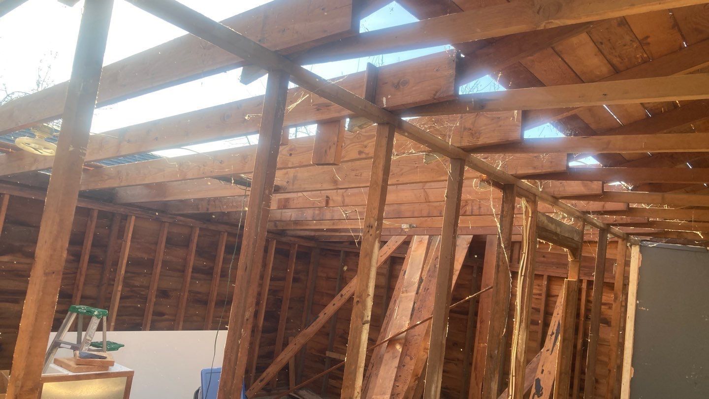 A room with a lot of wooden beams and a ladder.