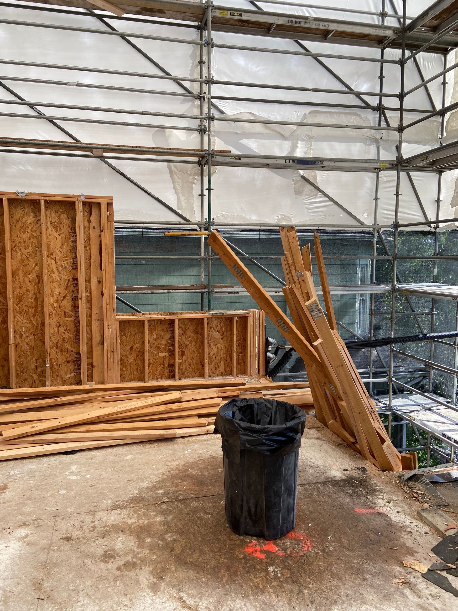 There is a trash can in the middle of a construction site.