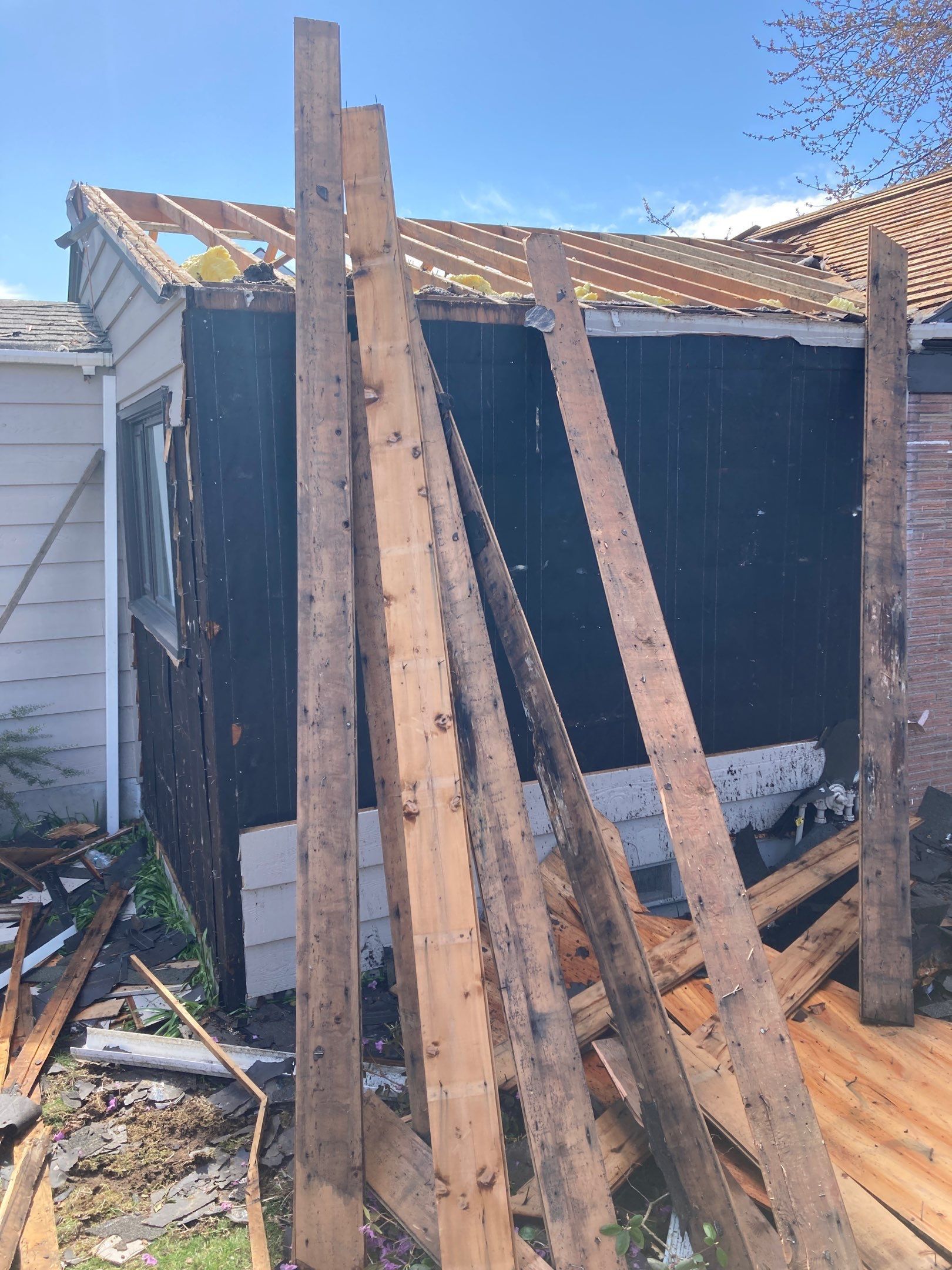 A pile of wood is sitting in front of a house.