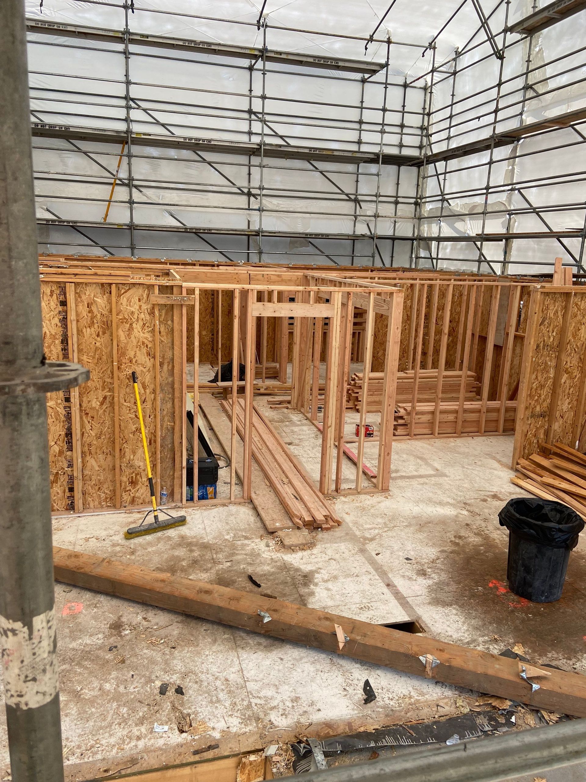 A building under construction with scaffolding and wooden walls.