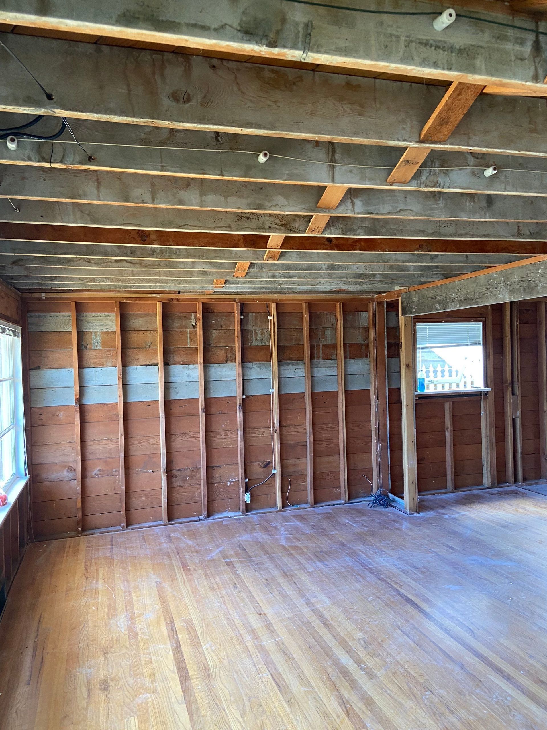An empty room with wooden beams and a window
