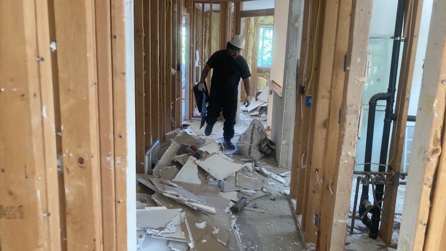 A man is walking through a hallway in a house under construction.