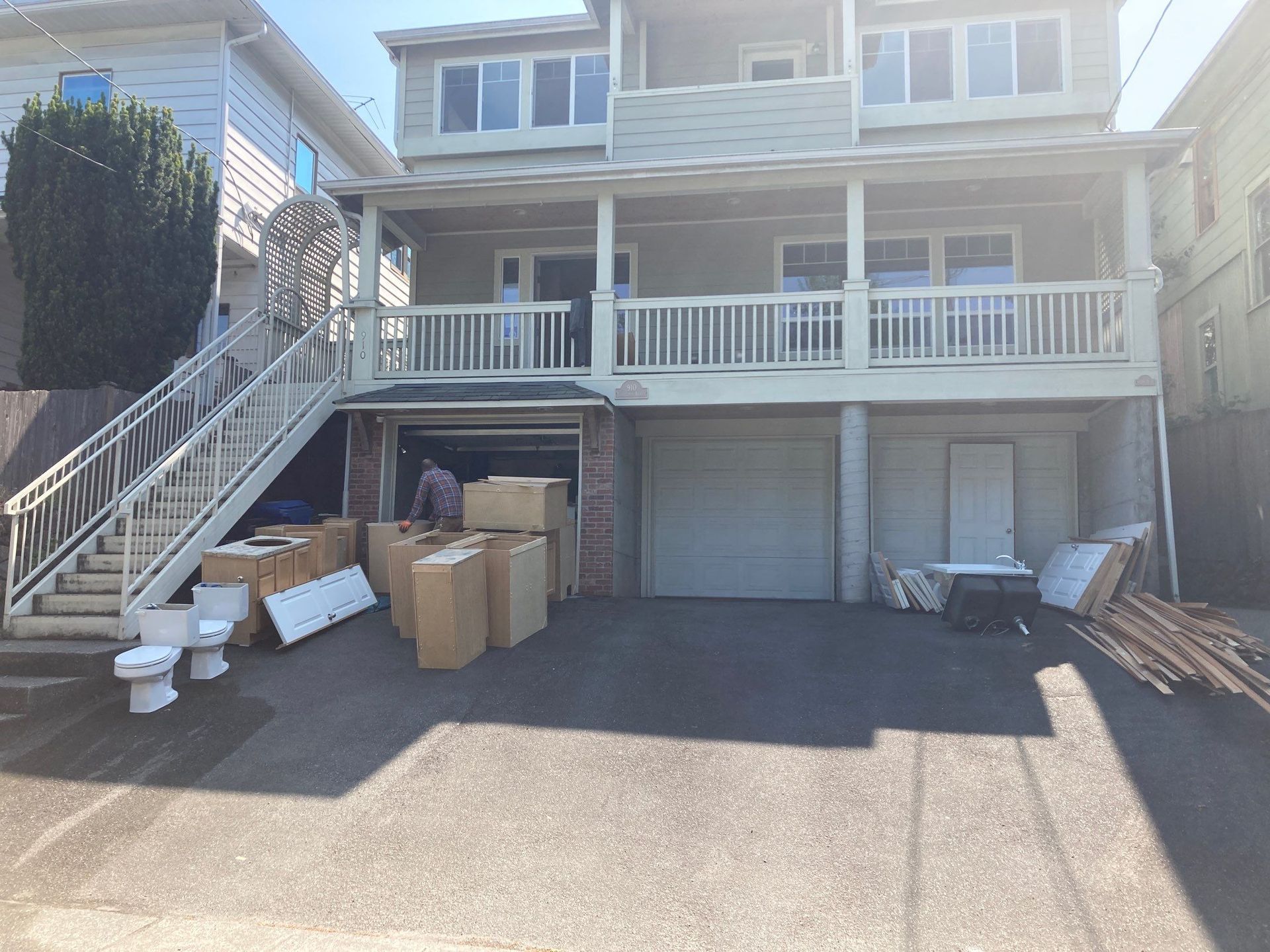 A man is loading boxes into a garage in front of a house.