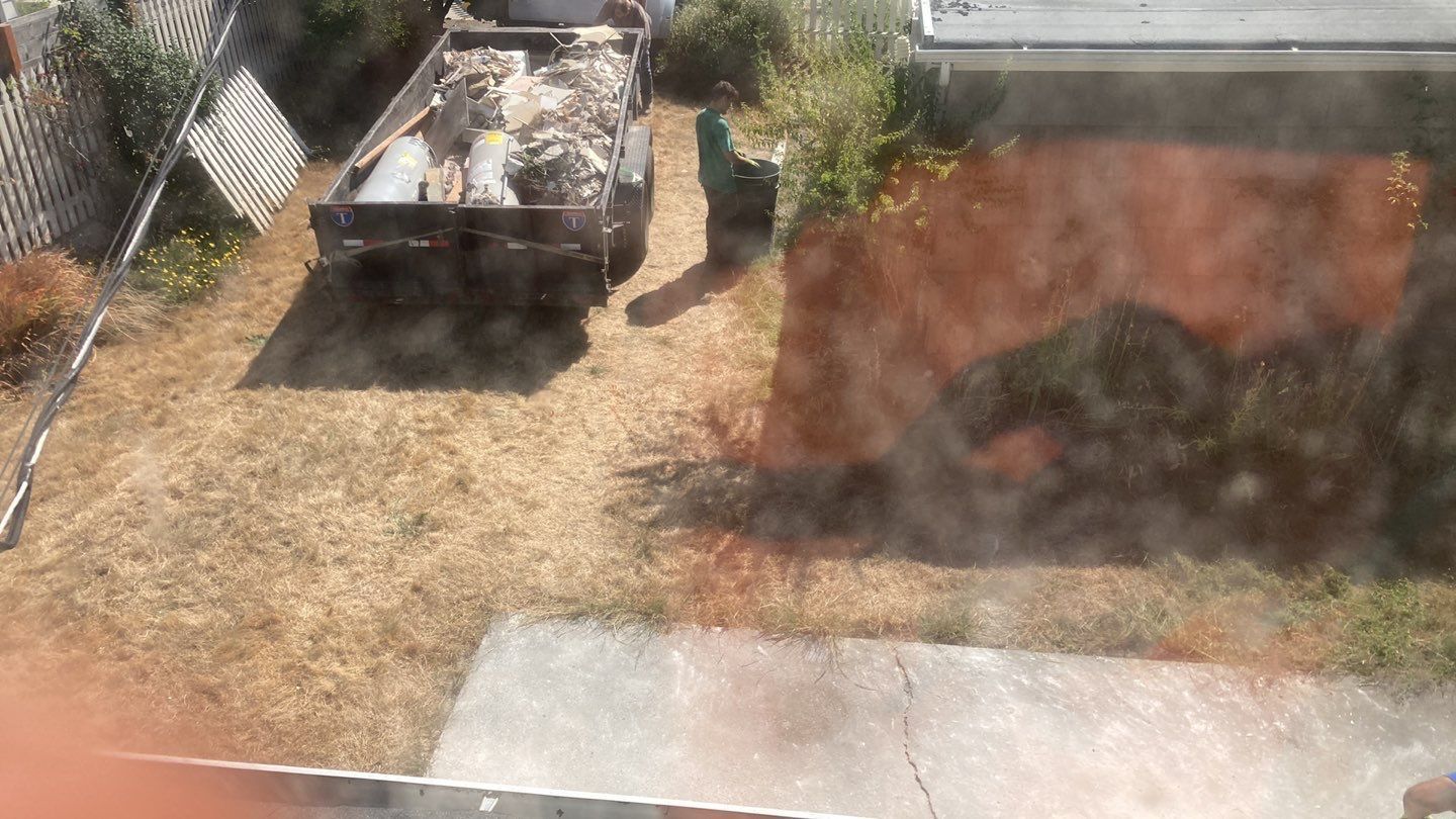 A truck is parked in a backyard next to a brick wall.