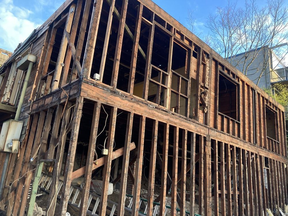 A large wooden building with a lot of windows is being demolished.