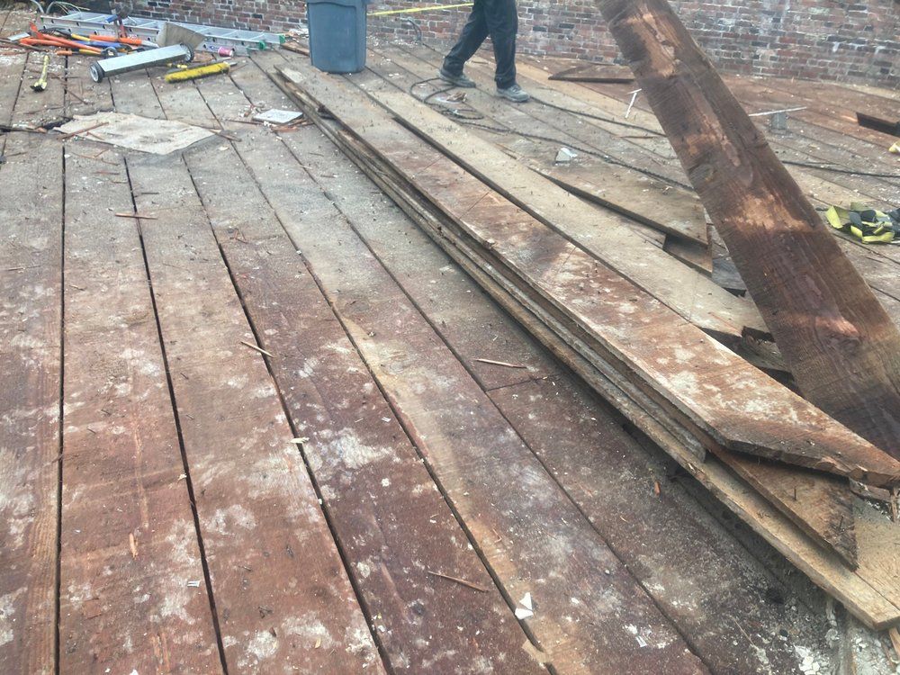 A pile of wood is sitting on top of a wooden deck.
