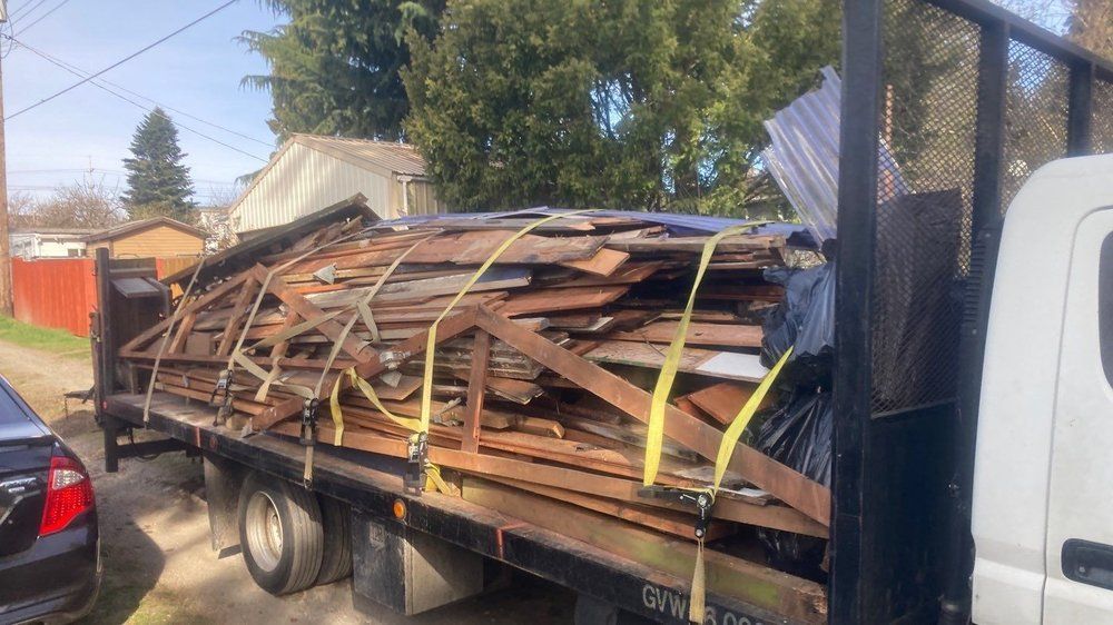 A tow truck is carrying a large pile of wood.