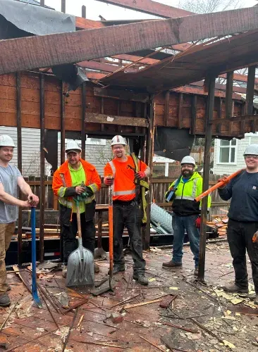 A group of construction workers are standing in front of a building under construction.