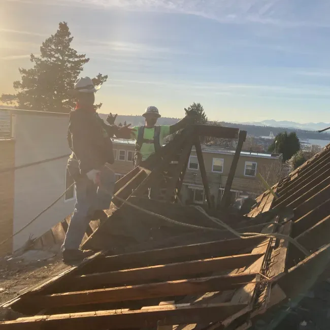 Two men are working on the roof of a building