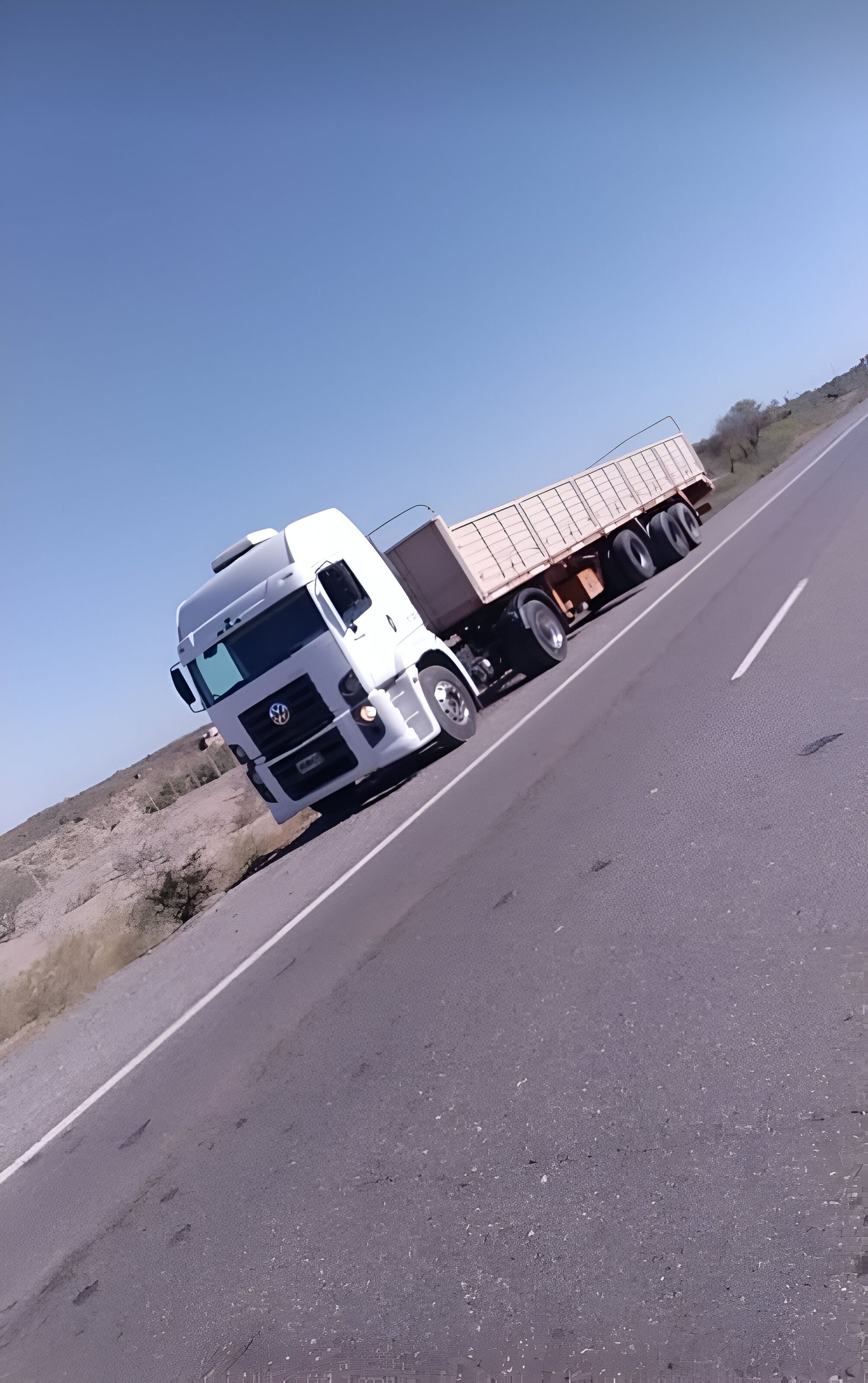 Un camión semirremolque blanco circula por una autopista.