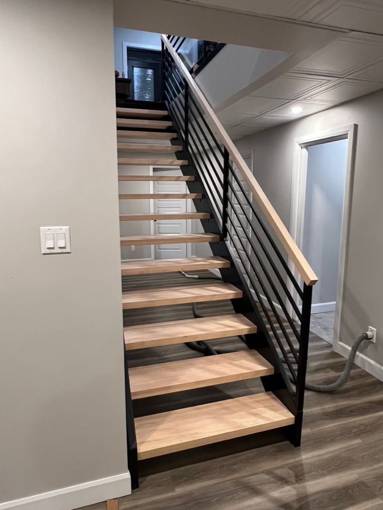Un escalier en bois avec une rampe en métal dans une pièce.